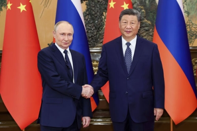 写真：ロシアのプーチン大統領（左）と握手する中国の習近平国家主席＝２日、北京の人民大会堂（新華社＝共同）