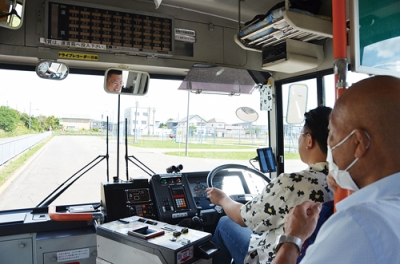 写真：乗務員の指導を受け、バスのハンドルを握る運転体験会の参加者