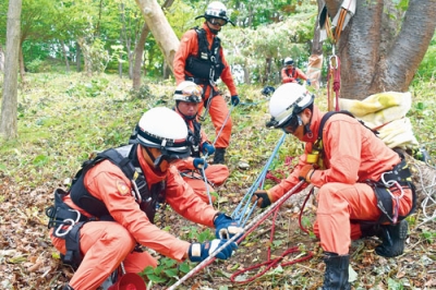 写真：連携して要救助者役をロープで引き上げる西胆振救助隊員たち