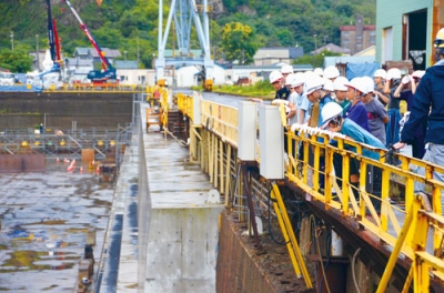 写真：室蘭製作所の乾ドックを見学する児童ら