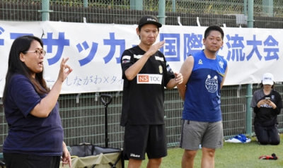 写真：交流キャンプで手話を使いコミュニケーションを取るデフサッカー男子日本代表元監督の植松隼人さん（中央）＝８月、東京都品川区