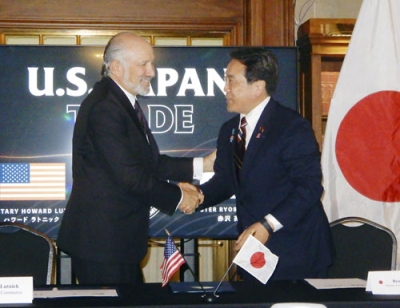 写真：日米関税合意に関する文書に署名し、握手する赤沢経済再生相（右）とラトニック米商務長官＝４日、ワシントン（共同）