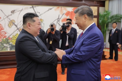 写真：握手する中国の習近平国家主席（右）と北朝鮮の金正恩朝鮮労働党総書記＝４日、北京の人民大会堂（朝鮮中央通信＝共同）
