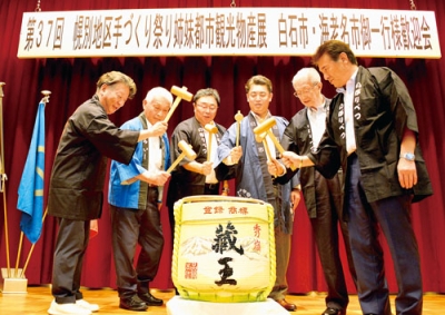 写真：３市１区の発展を願って鏡割りをする小笠原市長（右から４人目）、山田市長（同３人目）ら