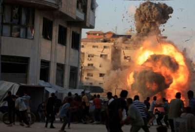 写真：イスラエルの空爆で建物が崩壊し、身構える人々＝７日、パレスチナ自治区ガザ市（ロイター＝共同）