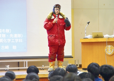 写真：南極で実際に着用した防寒着を着て登場した古崎さん