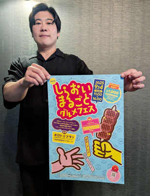 写真：ポスターを手に来場を呼びかける青山部長