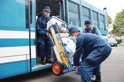 写真：警察施設に到着し、人員輸送車から機材などを降ろす署員
