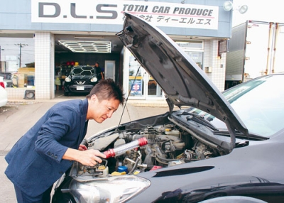 写真：さびなど車の状態を確認し査定をする門馬代表取締役