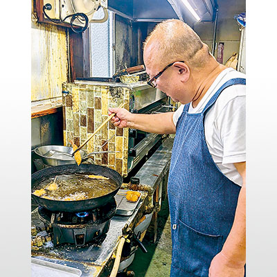 写真：真剣な表情で「串揚げ」を揚げている波多野代表