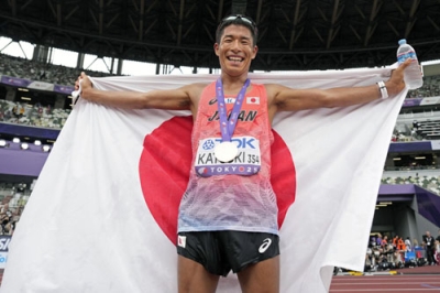 写真：陸上の第２０回世界選手権東京大会の男子３５キロ競歩で銅メダルを獲得し、日の丸を掲げる勝木隼人＝１３日、東京・国立競技場