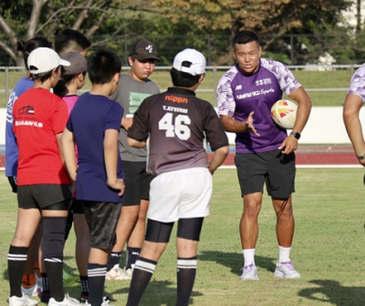 写真：ラグビー教室で子どもたちを指導する東京ベイの岸岡智樹（右）＝東京都足立区