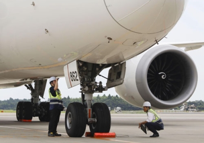 写真：成田空港の駐機場で機体チェックをする国交省の担当者ら＝８月