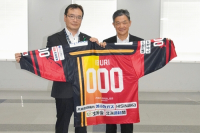 写真：背番号「０００」のレプリカユニホームを寄贈したレッドイーグルスの飯塚社長（右）