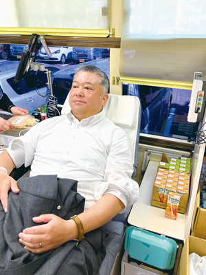 写真：献血に協力する松本副会長（提供写真）
