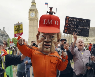 写真：ロンドンで、鎖につながれたトランプ米大統領を模して抗議の意を示すデモ参加者＝１７日（共同）
