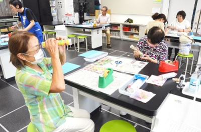 写真：制作した万華鏡の出来栄えを確認する参加者