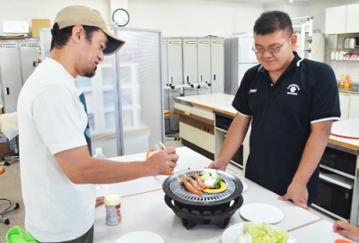 写真：用意されたこんろと鍋で食材を焼き、バーベキューを楽しむ来場者ら
