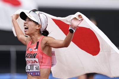 写真：女子２０キロ競歩　銅メダルを獲得し、日の丸を掲げる藤井菜々子＝国立競技場