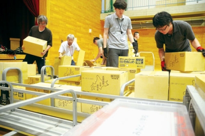 写真：備蓄品を搬入する市職員＝１６日、みなと小