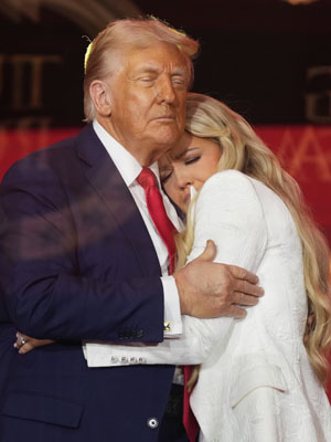 写真：チャーリー・カーク氏の追悼式典で、カーク氏の妻（右）と抱き合うトランプ米大統領＝２１日、アリゾナ州グレンデール（ＡＰ＝共同）