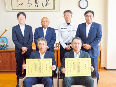 写真：感謝状を受け取った草塩代表（前列左）と昆社長（同右）