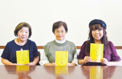 写真：完成したリレー小説「こころ」を手にする前田代表（左）と笹谷さん（中央）、藤原さん