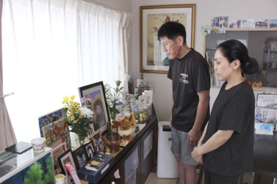 写真：久保田大治郎さんの遺影を見つめる母真実さん（右）と父純司さん＝８月、東京都八王子市