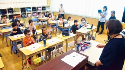写真：宮武さん（右）の指導を受けながら手話を練習する児童たち