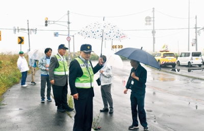 写真：死亡事故現場となった交差点近くで現場診断を行う関係者