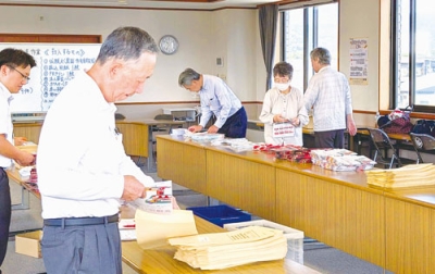 写真：寄付依頼書を封筒に納める奉仕員