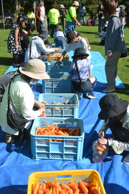 写真：ビンゴ大会を勝ち抜き野菜詰め放題に挑戦する参加者たち