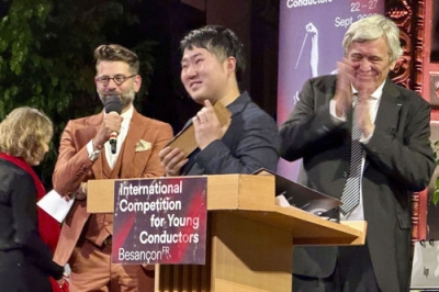 写真：２７日、ブザンソン国際若手指揮者コンクールの授賞式で喜ぶ米田覚士さん（中央）＝フランス東部ブザンソン（共同）