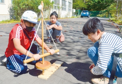 写真：火おこしに挑戦する子どもたち