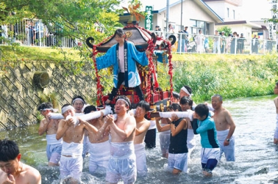 写真：腰までぬらしながら壮瞥川を進むみこしの担ぎ手たち