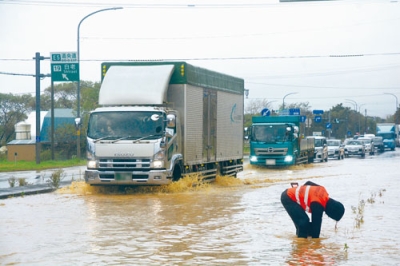 写真：冠水した国道３６号を通行するトラック＝１日午後１時４０分ごろ、白老町社台