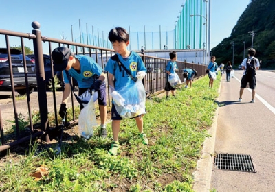 写真：道の駅に向かいながらごみを拾う港南ＦＣの子どもたち