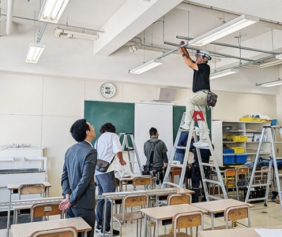写真：プロジェクターのつり下げ器具などを取り付ける青年部の部員