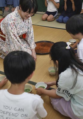 写真：茶の湯体験で茶わんを手にする子どもたち