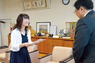 写真：小笠原市長から辞令を受け取る木村さん（左）