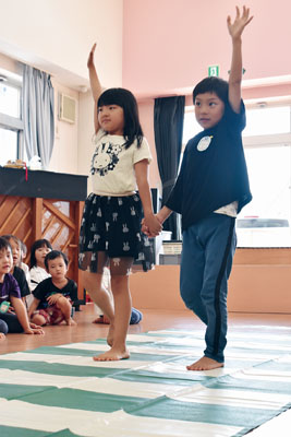写真：まっすぐ手を上げ、正しい横断歩道の渡り方を学ぶ園児