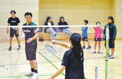 写真：実技交流でアドバイスを送る佐々木さん（左から２人目）