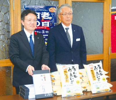 写真：新米を寄贈した石橋専務（右）と大塩町長
