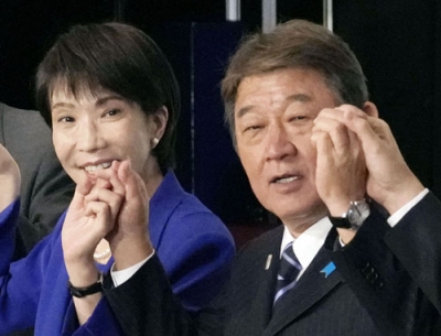 写真：４日、自民党総裁選後の両院議員総会で手を取り合う茂木前幹事長（右）と高市総裁＝東京・永田町の党本部