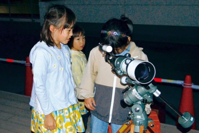 写真：望遠鏡で室蘭の夜景を見る参加者