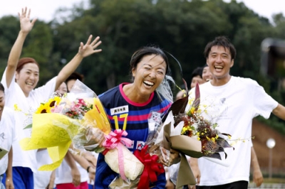 写真：引退セレモニーで笑顔を見せる永里優季さん。左は妹亜紗乃さん、右は兄源気さん＝神奈川県厚木市