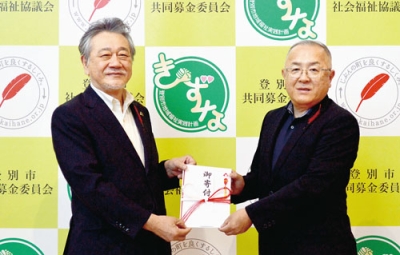 写真：仲川会長に益金を手渡す菅原会長（右）