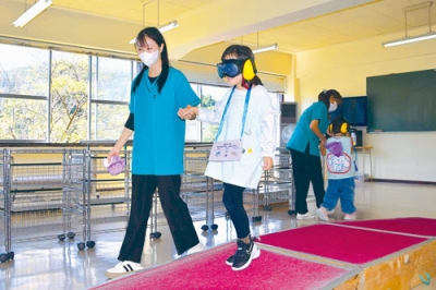 写真：ゴーグルとイヤーマフを着けて歩く園児