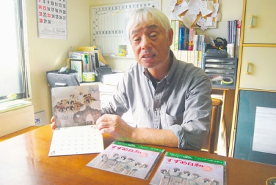 写真：発刊したカレンダー「すずめ日和」を手にする熊谷さん