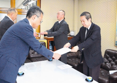 写真：要請書を手渡す日西会長（右端）と岡村教育研究部長（右から２人目）